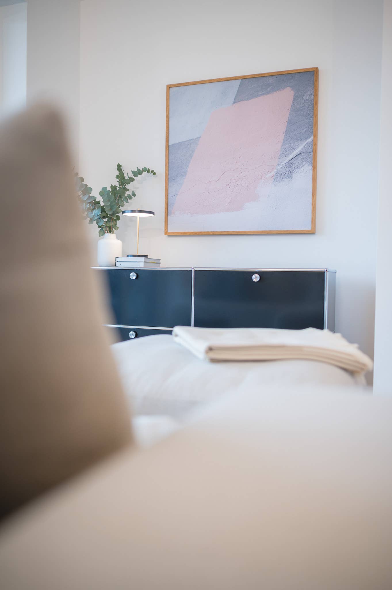 Pastellfarbenes Akustikbild von Akustikwerke mit Eichenrahmen über Sideboard im Schlafzimmer