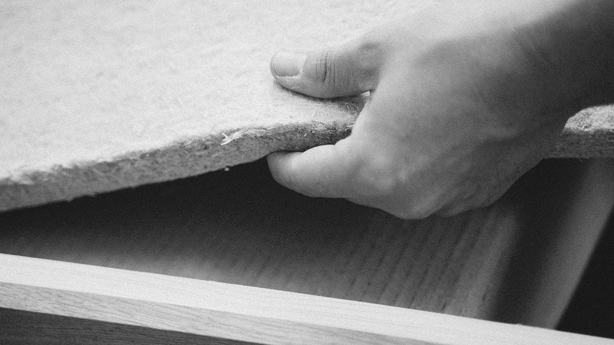 a man in an image holding the one inch sound proof sheet to be place on wall for decoration 