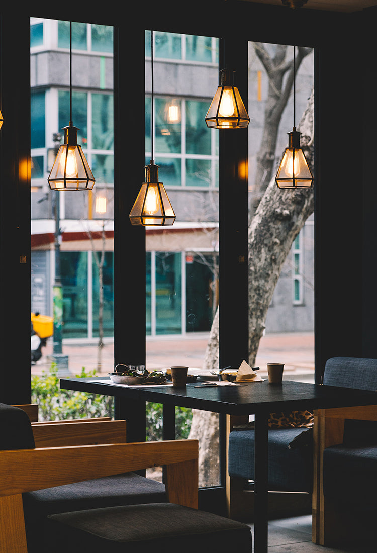 Bild eines Restaurants mit großem Fenster und hellen Lampen im Vordergrund