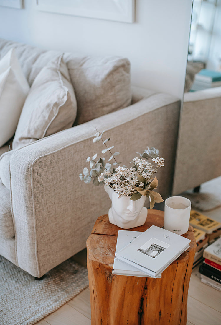 Bild eines Wohnzimmers mit hellem Sofa und Beistelltisch aus Holz