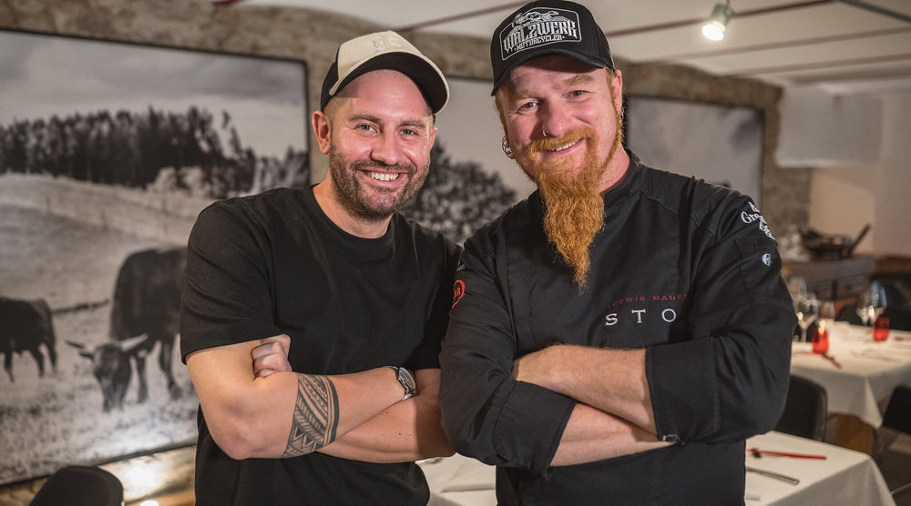 an image shows two man smiling with folding hands