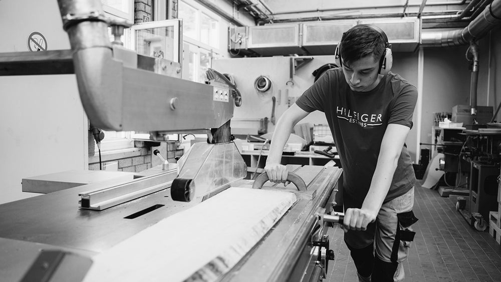 a man cutting wood pieces in the factory to make wall decore image   